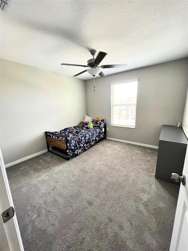 bedroom featuring a textured ceiling, carpet floors, and ceiling fan