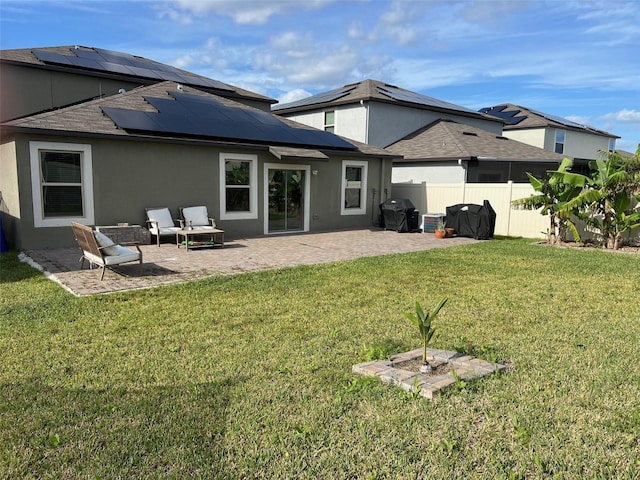 rear view of house with an outdoor living space, solar panels, a yard, and a patio