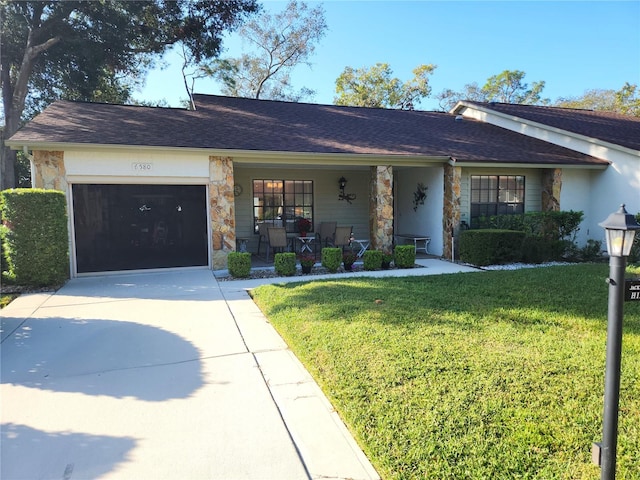 single story home featuring a porch, a garage, and a front yard