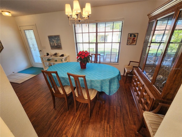 dining room with a notable chandelier and dark wood-type flooring