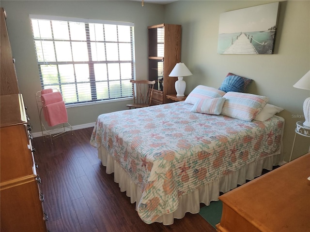 bedroom with dark hardwood / wood-style flooring and multiple windows