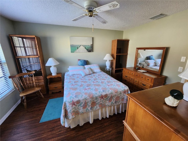 bedroom featuring ceiling fan, dark wood-type flooring, and a textured ceiling