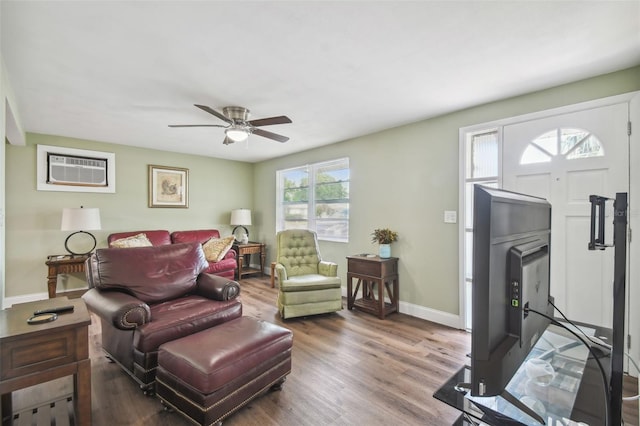 living room featuring an AC wall unit, hardwood / wood-style floors, and ceiling fan