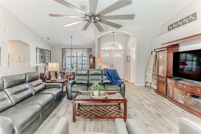 living room with light hardwood / wood-style floors, vaulted ceiling, and ceiling fan