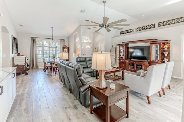 living room featuring ceiling fan, light wood-type flooring, and vaulted ceiling