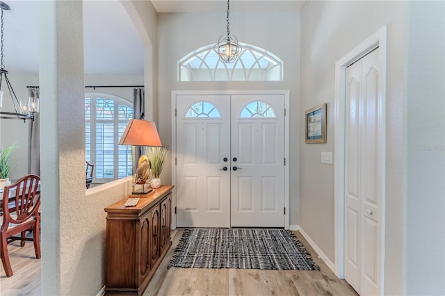 entryway with an inviting chandelier and light wood-type flooring