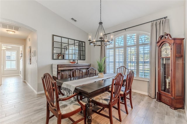 dining area with plenty of natural light, light hardwood / wood-style floors, and a chandelier