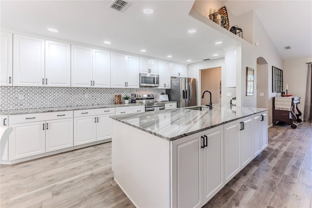 kitchen with white cabinetry, light wood-type flooring, sink, and appliances with stainless steel finishes