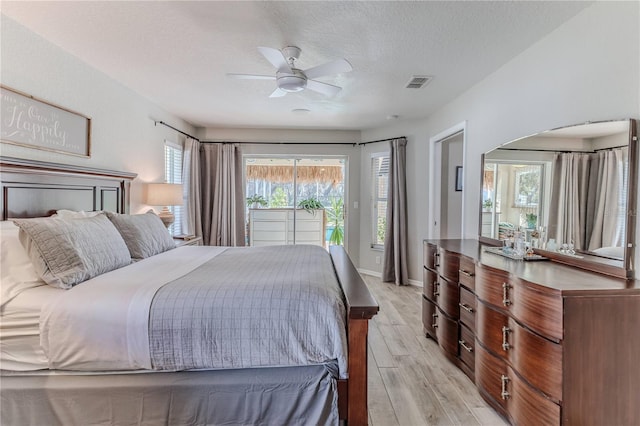 bedroom with ceiling fan, light hardwood / wood-style floors, access to exterior, and a textured ceiling