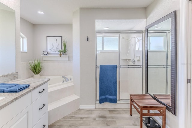 bathroom featuring hardwood / wood-style flooring, vanity, and independent shower and bath