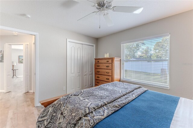 bedroom featuring light wood-type flooring, a closet, and ceiling fan