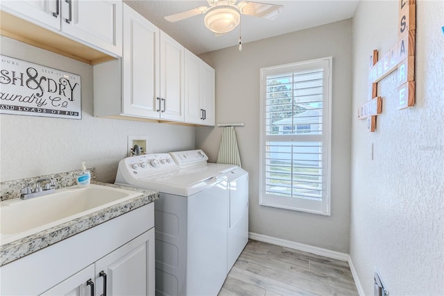 clothes washing area featuring cabinets, light wood-type flooring, ceiling fan, sink, and separate washer and dryer