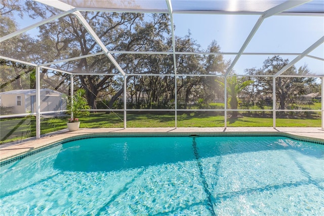 view of pool featuring a lawn and glass enclosure