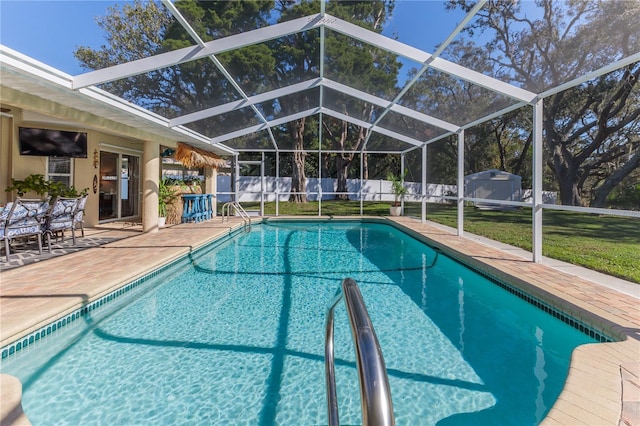 view of pool with glass enclosure, a yard, and a patio