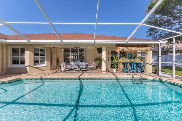 view of swimming pool featuring glass enclosure and a patio area