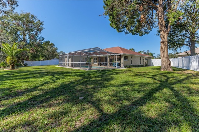 view of yard with a fenced in pool and glass enclosure