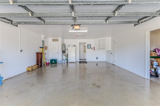 garage featuring white refrigerator and a garage door opener