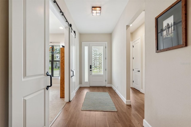 doorway with light hardwood / wood-style flooring and a barn door