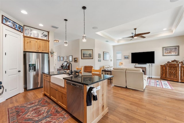 kitchen with light hardwood / wood-style floors, sink, a center island with sink, and stainless steel appliances