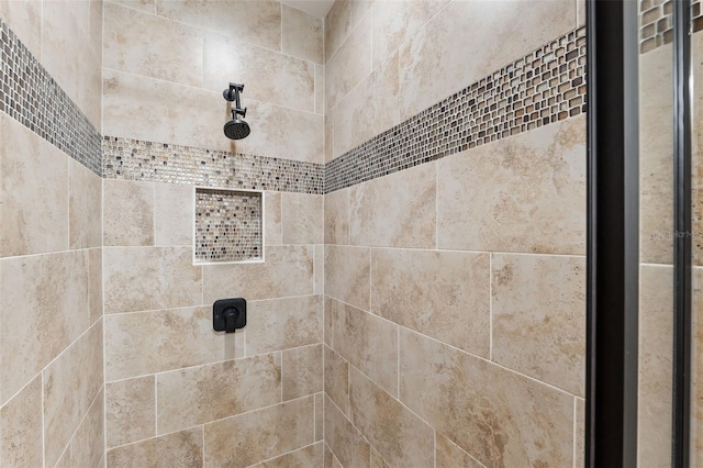 interior details featuring tiled shower