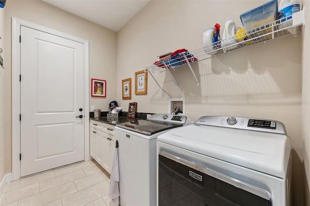 clothes washing area featuring cabinets, light tile patterned floors, and independent washer and dryer