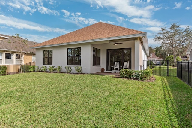 back of house with a lawn and ceiling fan