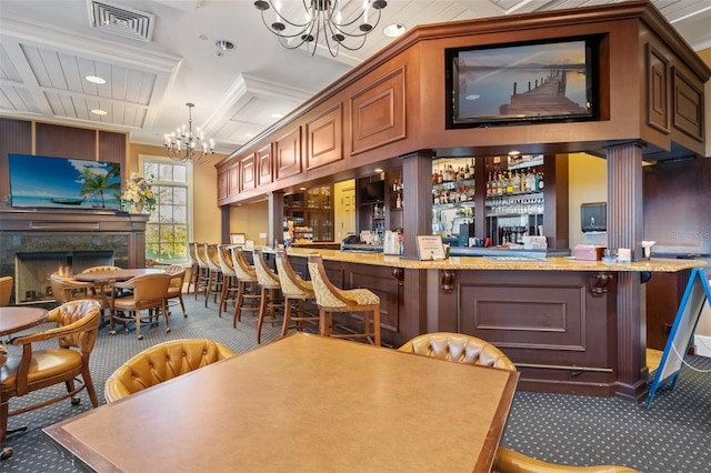 bar featuring an inviting chandelier, carpet floors, crown molding, a fireplace, and decorative light fixtures