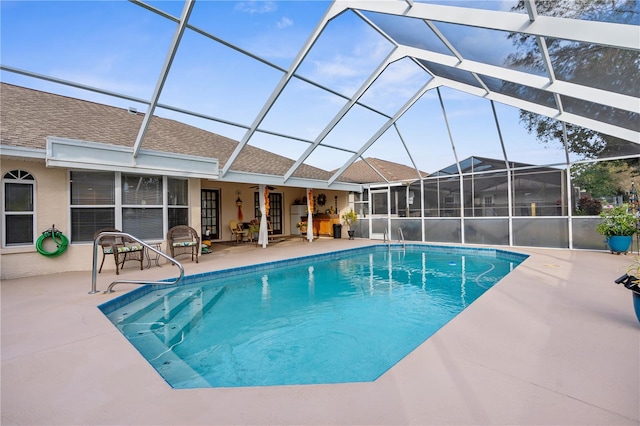 view of pool featuring glass enclosure, ceiling fan, and a patio area