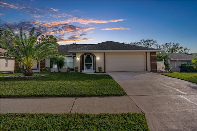 ranch-style house with a lawn and a garage