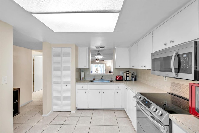 kitchen featuring white cabinets, light tile patterned floors, sink, and appliances with stainless steel finishes