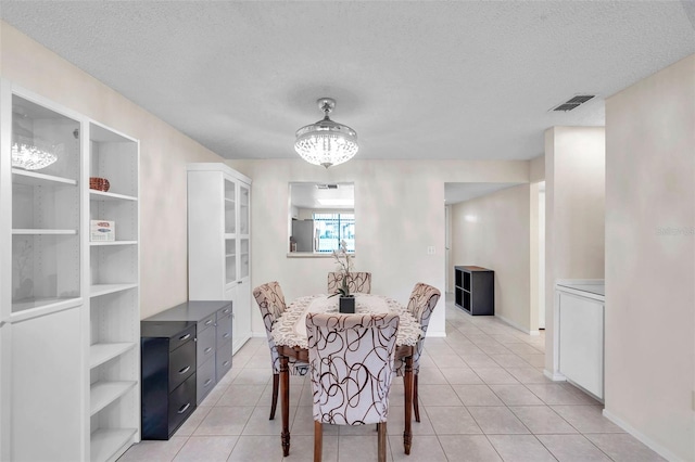 dining room featuring light tile patterned floors and a textured ceiling