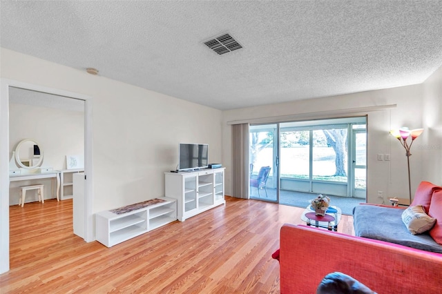 living room with wood-type flooring and a textured ceiling