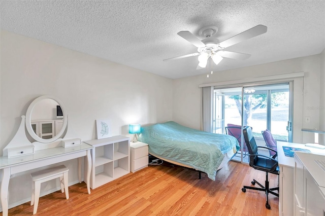 bedroom with ceiling fan, a textured ceiling, and light wood-type flooring