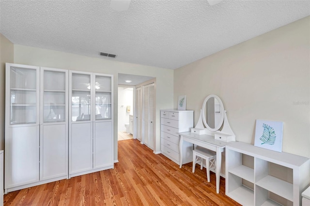 interior space featuring a textured ceiling and light wood-type flooring