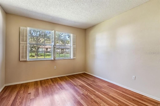 spare room featuring a textured ceiling and hardwood / wood-style flooring