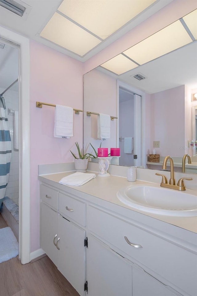 bathroom with a shower with curtain, vanity, and hardwood / wood-style flooring