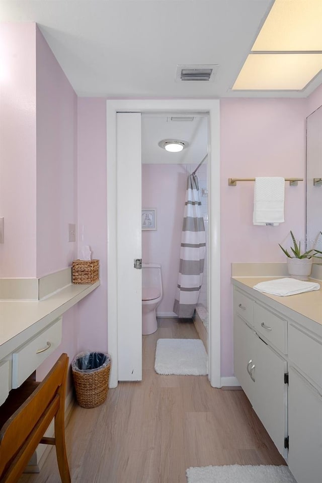8141 Aquila St Unit 347, Port Richey, FL 34668 - full bath with vanity, toilet, wood finished floors, a shower with shower curtain, and baseboards