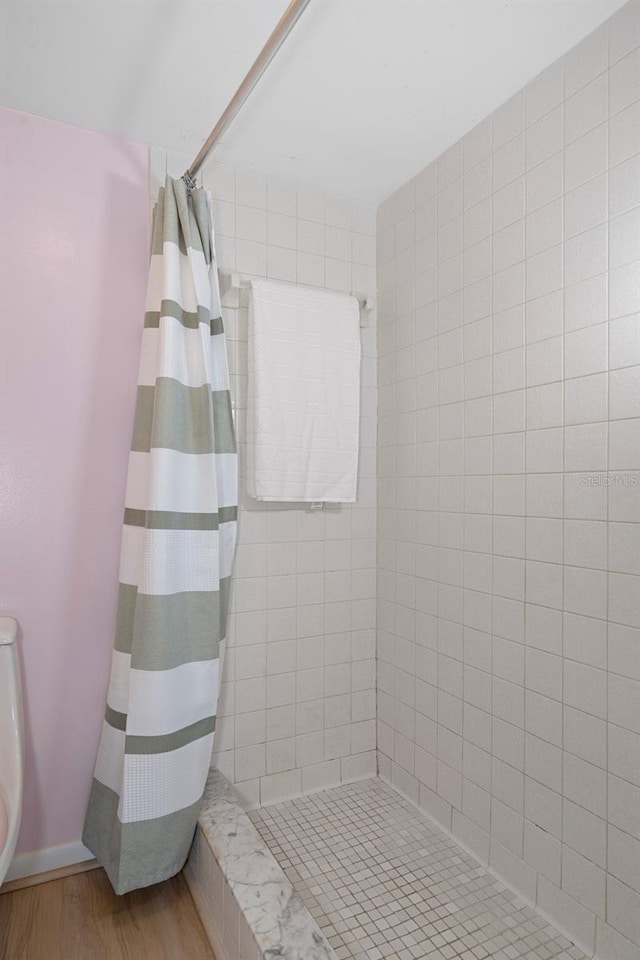 8141 Aquila St Unit 347, Port Richey, FL 34668 - full bathroom featuring a tile shower, wood finished floors, and baseboards