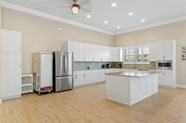 kitchen with white cabinets, light wood-type flooring, and stainless steel appliances
