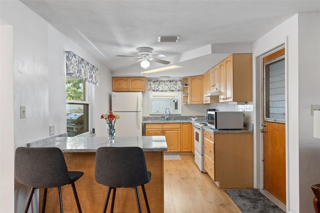 kitchen with ceiling fan, light brown cabinetry, white appliances, and light wood-type flooring