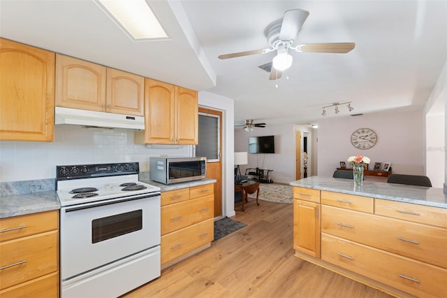 kitchen featuring electric range, light brown cabinets, light hardwood / wood-style floors, and light stone counters