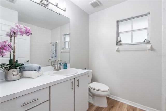 bathroom featuring vanity, hardwood / wood-style floors, curtained shower, and toilet