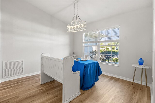 interior space featuring an inviting chandelier and light hardwood / wood-style flooring