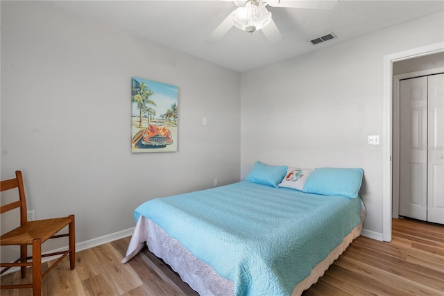 bedroom featuring hardwood / wood-style flooring, ceiling fan, and a closet