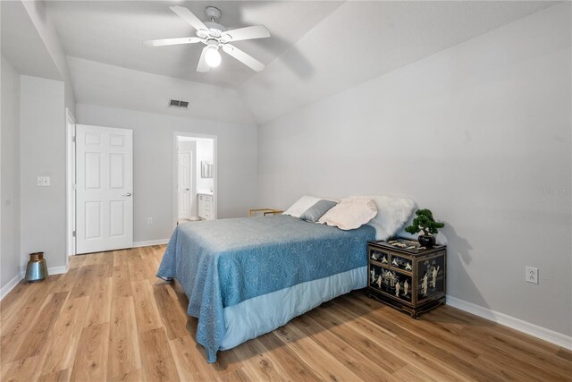 bedroom with ceiling fan, lofted ceiling, ensuite bathroom, and light hardwood / wood-style flooring