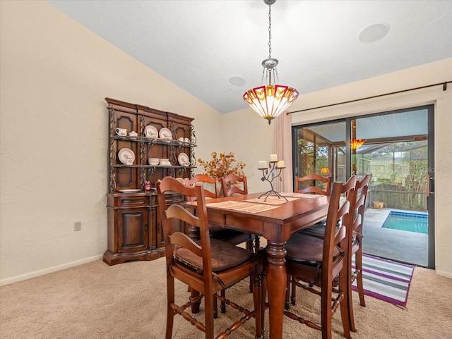 carpeted dining room featuring lofted ceiling