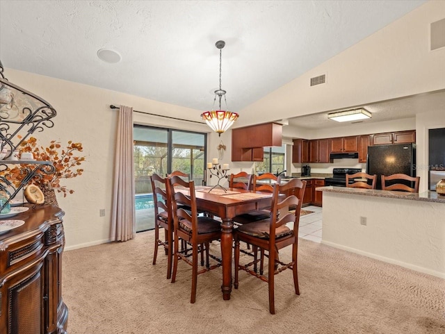 carpeted dining space featuring a textured ceiling, sink, and vaulted ceiling