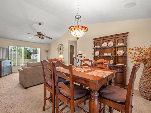 carpeted dining area featuring ceiling fan, lofted ceiling, and a textured ceiling