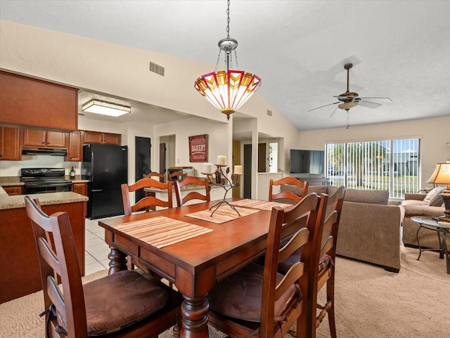 carpeted dining space featuring ceiling fan with notable chandelier and vaulted ceiling