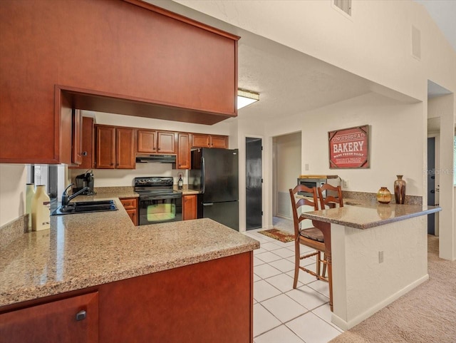 kitchen with a kitchen bar, black appliances, sink, light stone counters, and kitchen peninsula